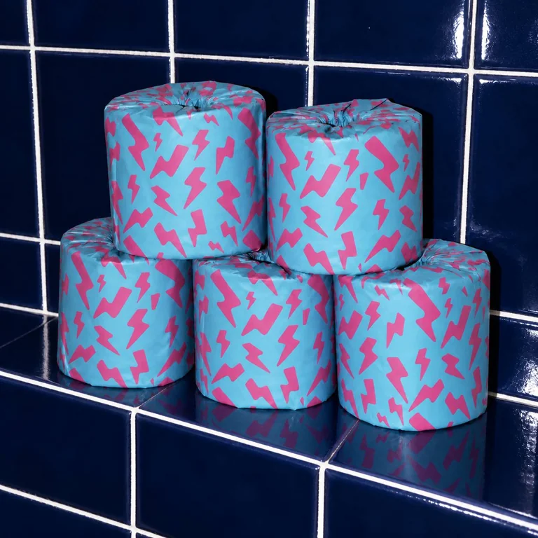 Five Skid Slayer rolls in cyan and pink printed wrappers on navy tiles